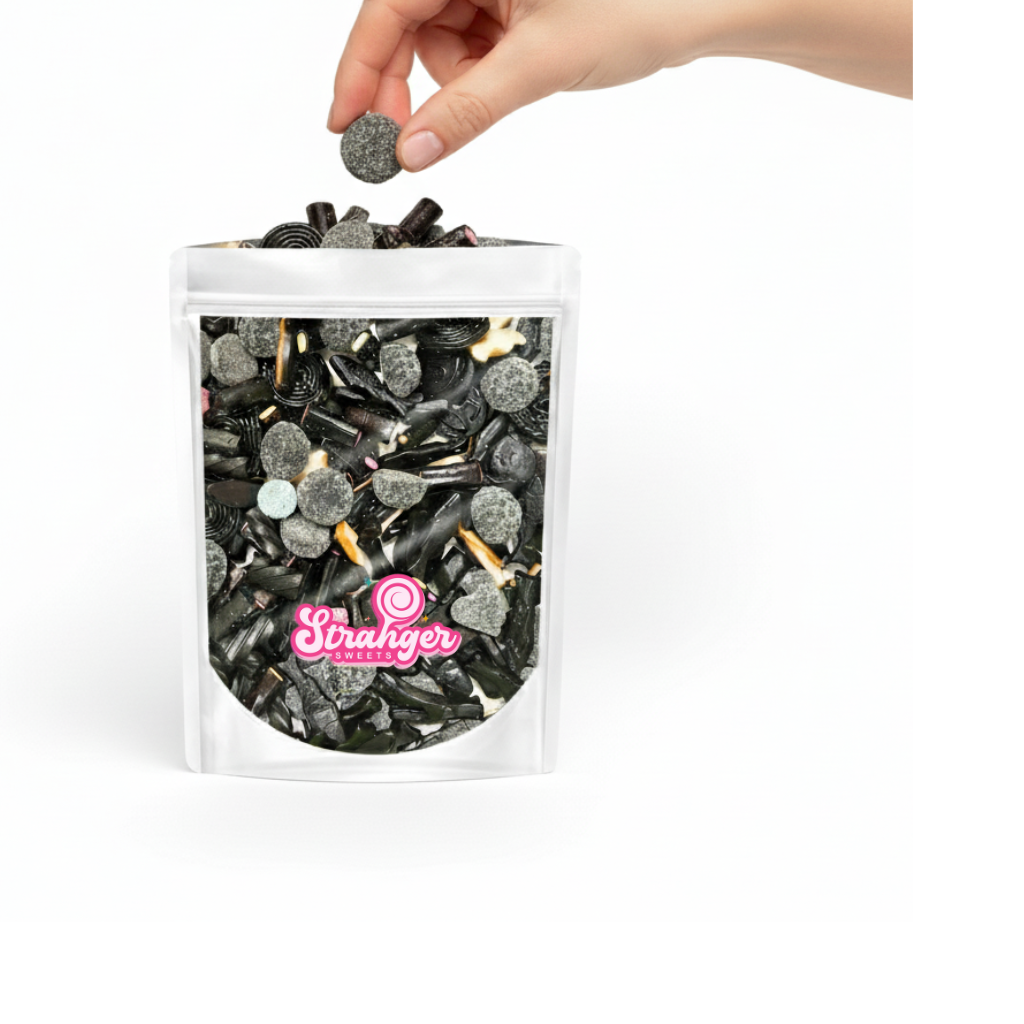 Caramelle gommose mix liquirizia - mano che sceglie caramella da mix nero alla liquirizia forme assortite